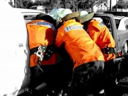 Voluntarios con equipo de rescate trabajando junto a un vehículo