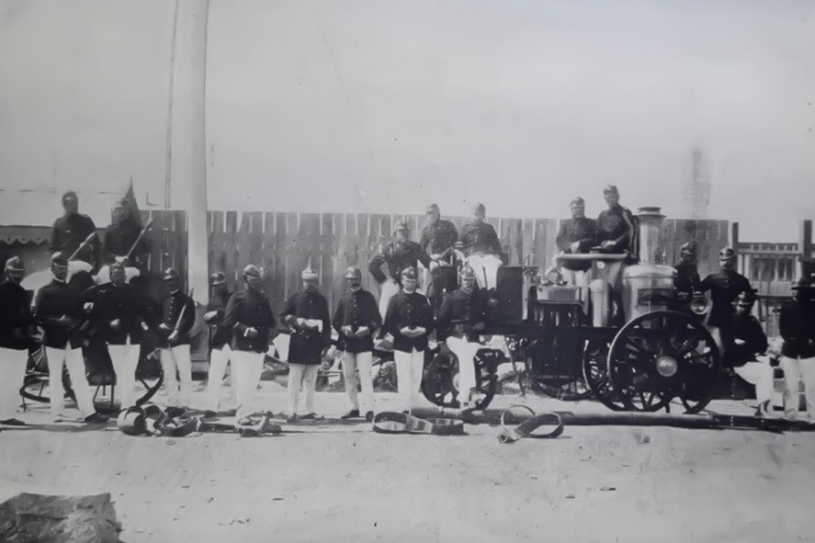 Voluntarios junto a una bomba a vapor en una fotografía del archivo histórico de la compañía
